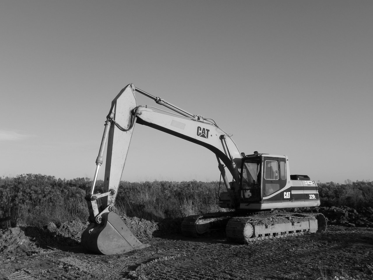 about-bg Monochrome image of an excavator at a construction site, ideal for industry themes.